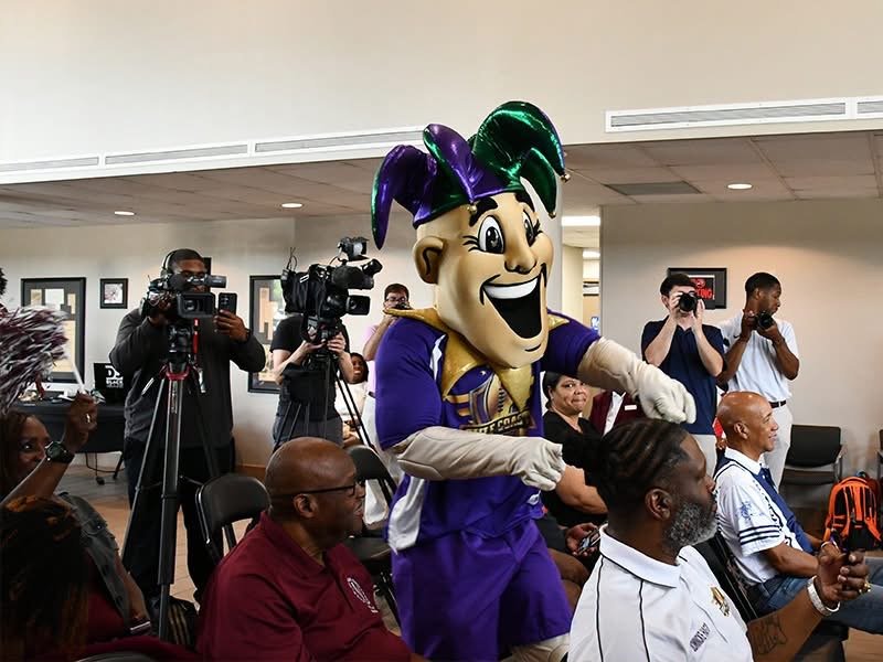 The Gulf Coast Challenge mascot interacts with media and attendees during the 2026 event announcement in Mobile, AL.