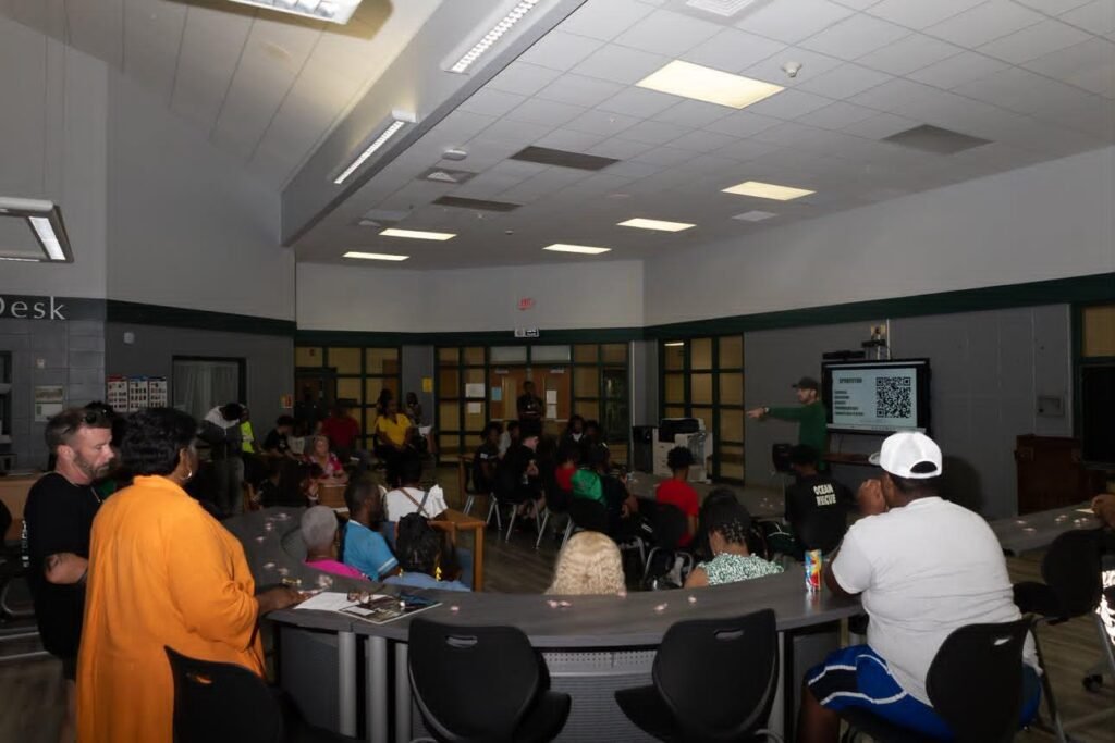 Vigor basketball players, parents, and local sports fans seated inside the media center listening to Coach Mike Hoffmann.
