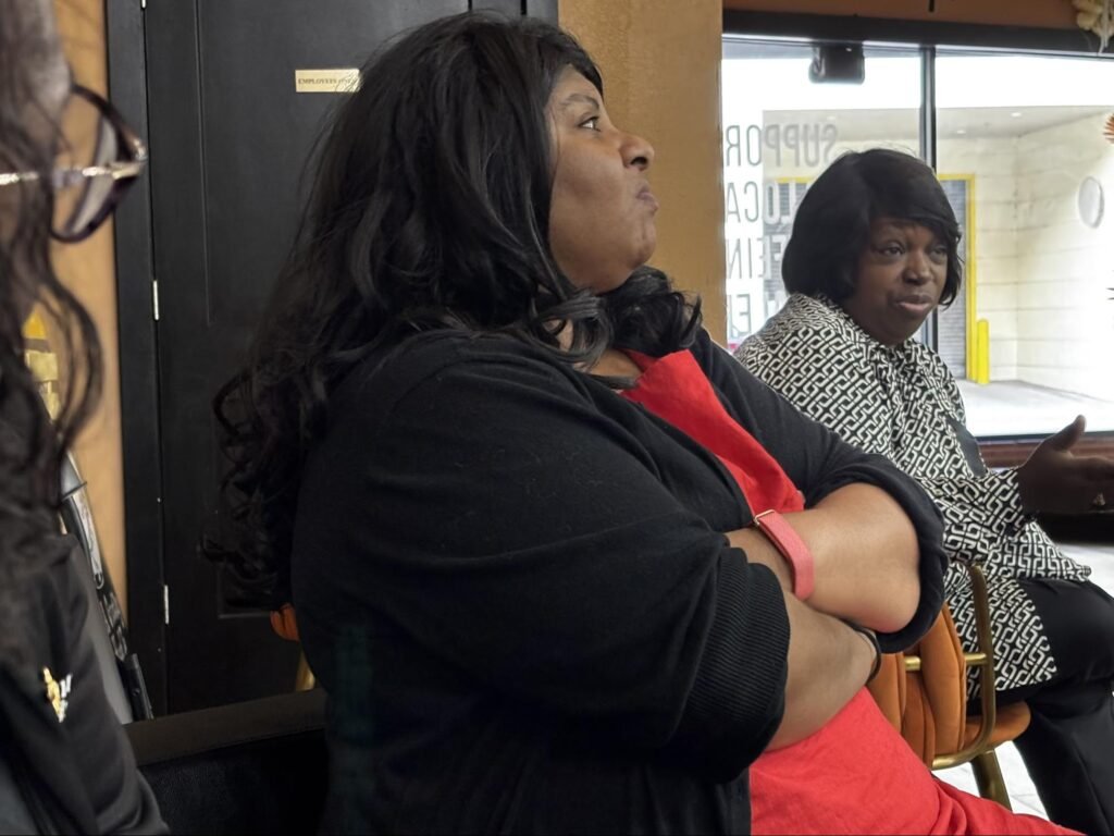 Community members and organizers sit together listening closely during the Civics & Conversation event