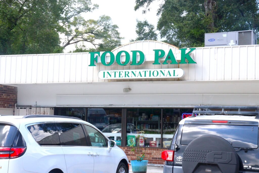 Front exterior view of the Food Pak International building with cars parked out front.