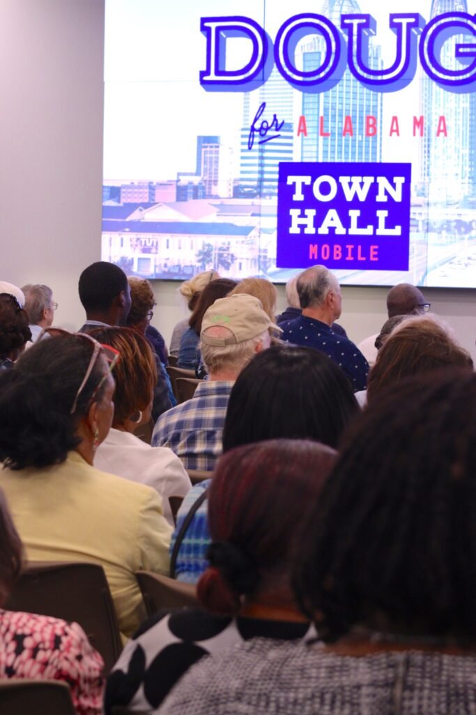 Audience members seated facing the stage during the "Doug for Alabama" town hall in Mobile.