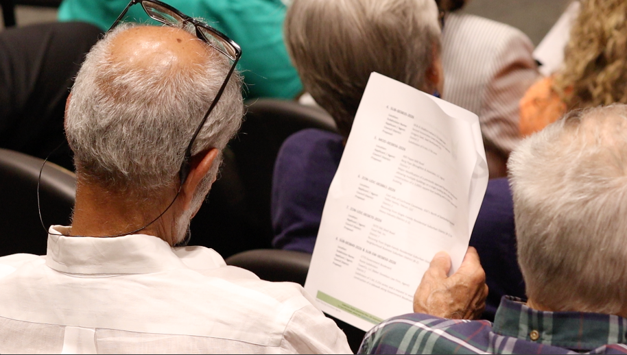 Food Pak co-owner Reza Hejazi reviewing meeting documents in the audience during the Mobile Planning Commission public hearing.
