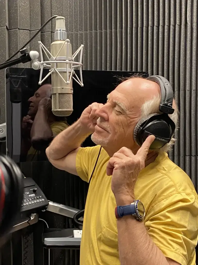 Jimmy Buffett wearing headphones in a recording studio.