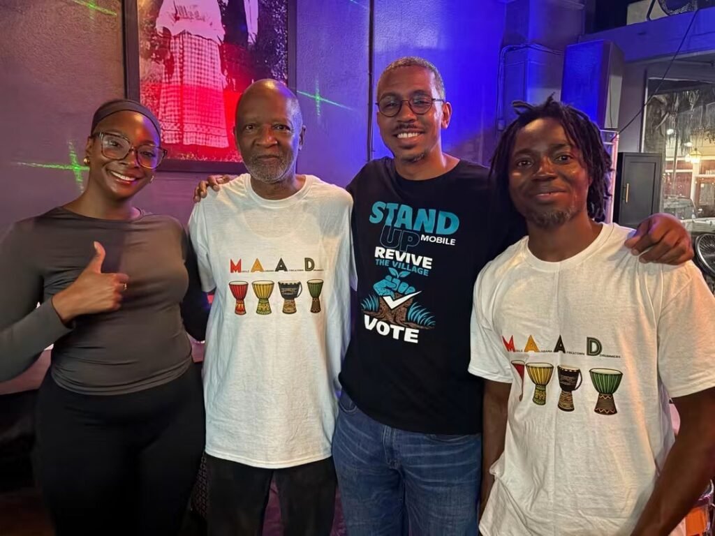 Representatives from Stand Up Mobile and the Mobile Alabama Africatown Drummers, including founder Wayne Curtis (second from left) and strategic consultant Reggie Weaver (third from left), gather with Beninese artist Yewhe Yeton at Kazoola.