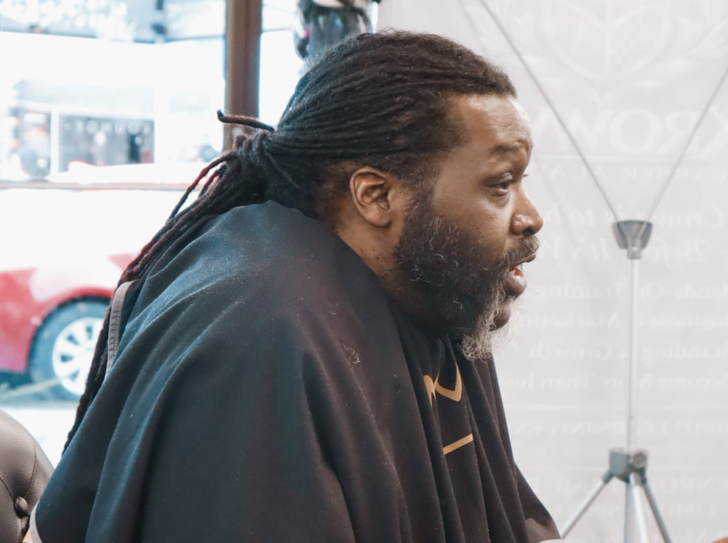 Panelist Huggy Bear Da Poet speaking during the Barbershop Talk Who Speaks for Us Mobile AL panel discussion.